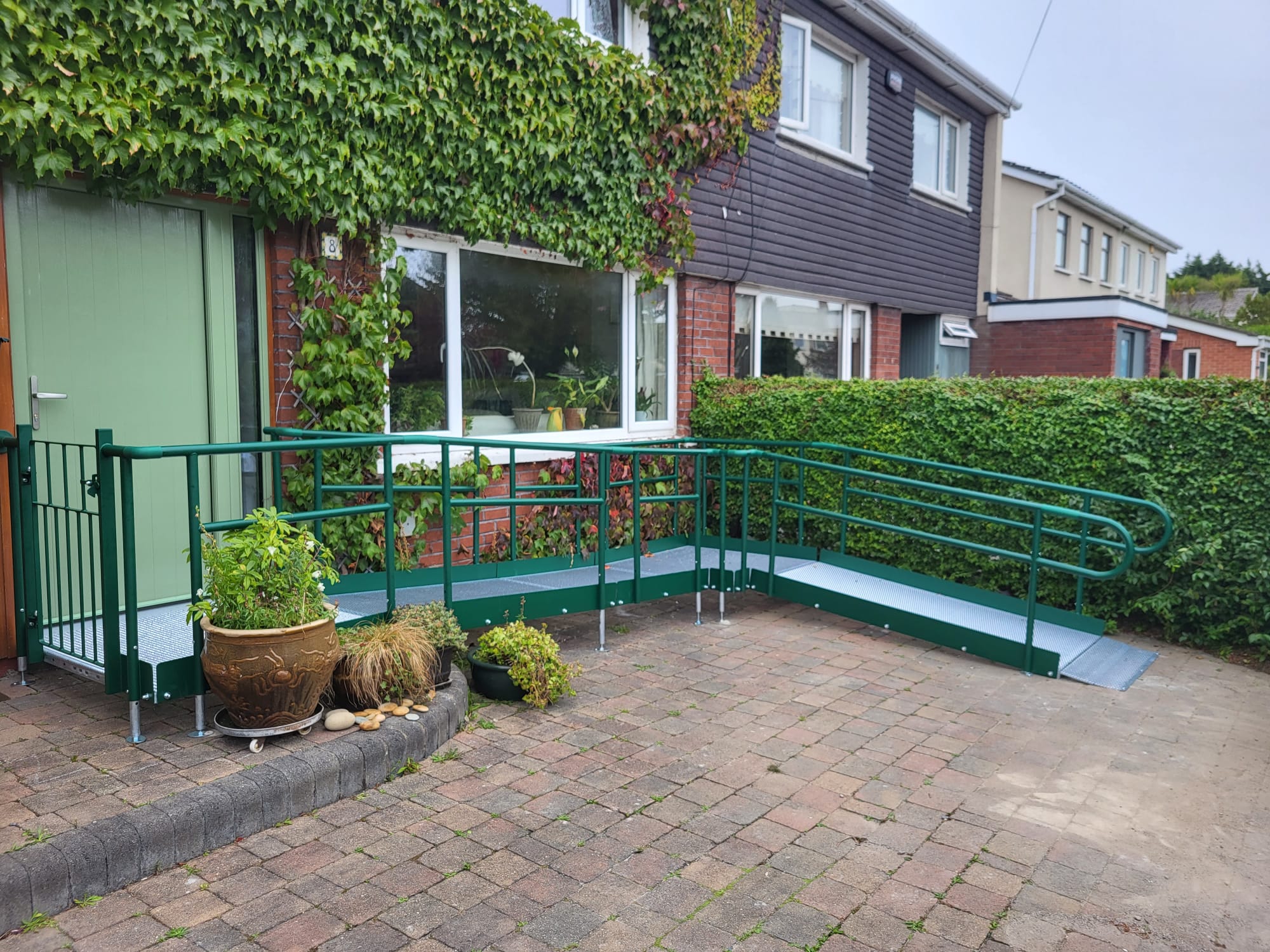 Green Modular ramp in an L Shape. Installed in a front garden